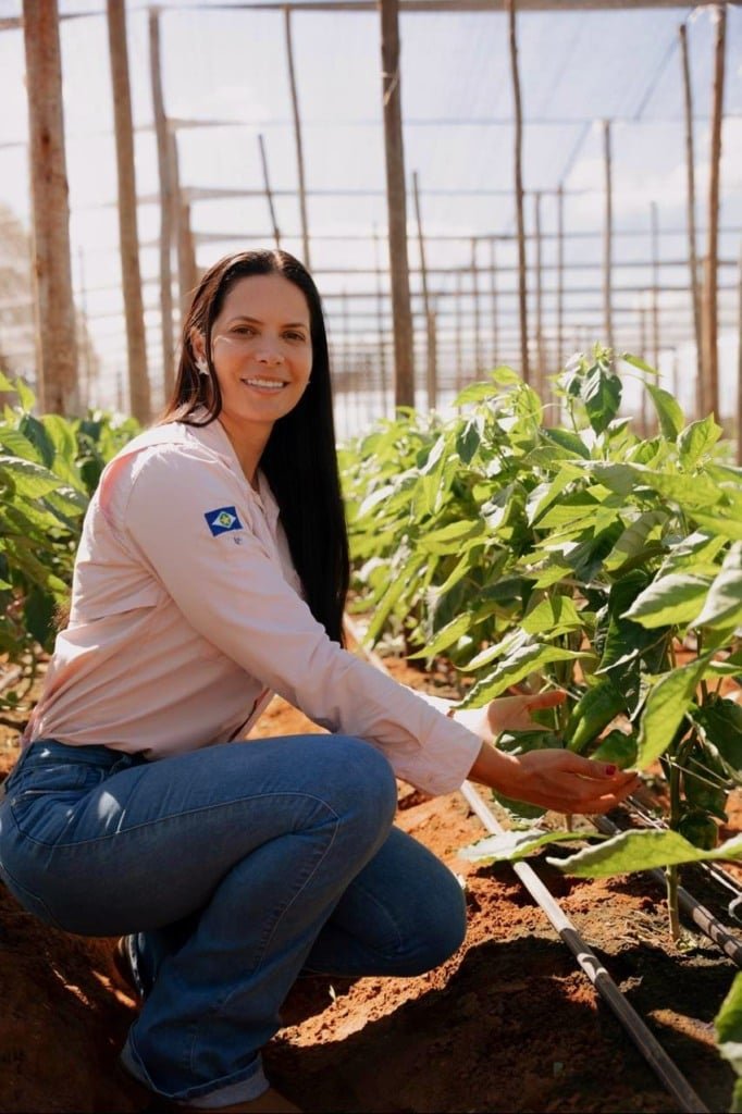 Na foto, aparece uma mulher em meio à plantação.